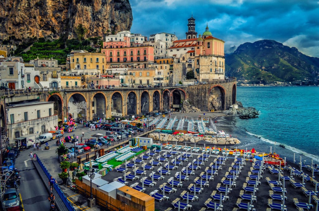 Atrani, Amalfi Coast, Italy, view of the beach side, sun loungers, town on the side of the clif, evening