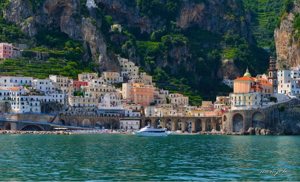 Atrani, Amalfi Coast, Italy, view of the town from the water, colourful buildings nad clifs of the mountain in background