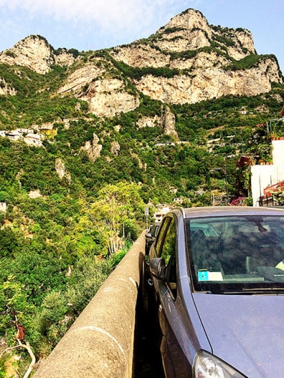 Parking space on the side of the road in Amalfi Coast, Italy, car parked very close to the concrete barrier, mirrors folded in