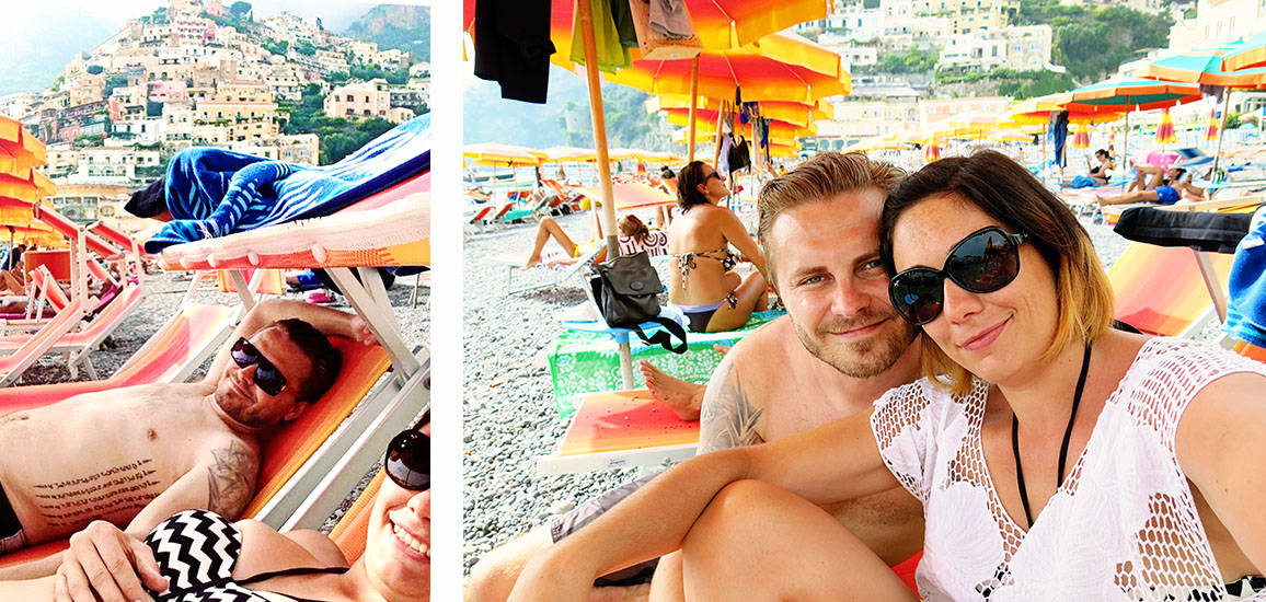 Positano beach, couple smiling, beach umbrellas and sun loungers