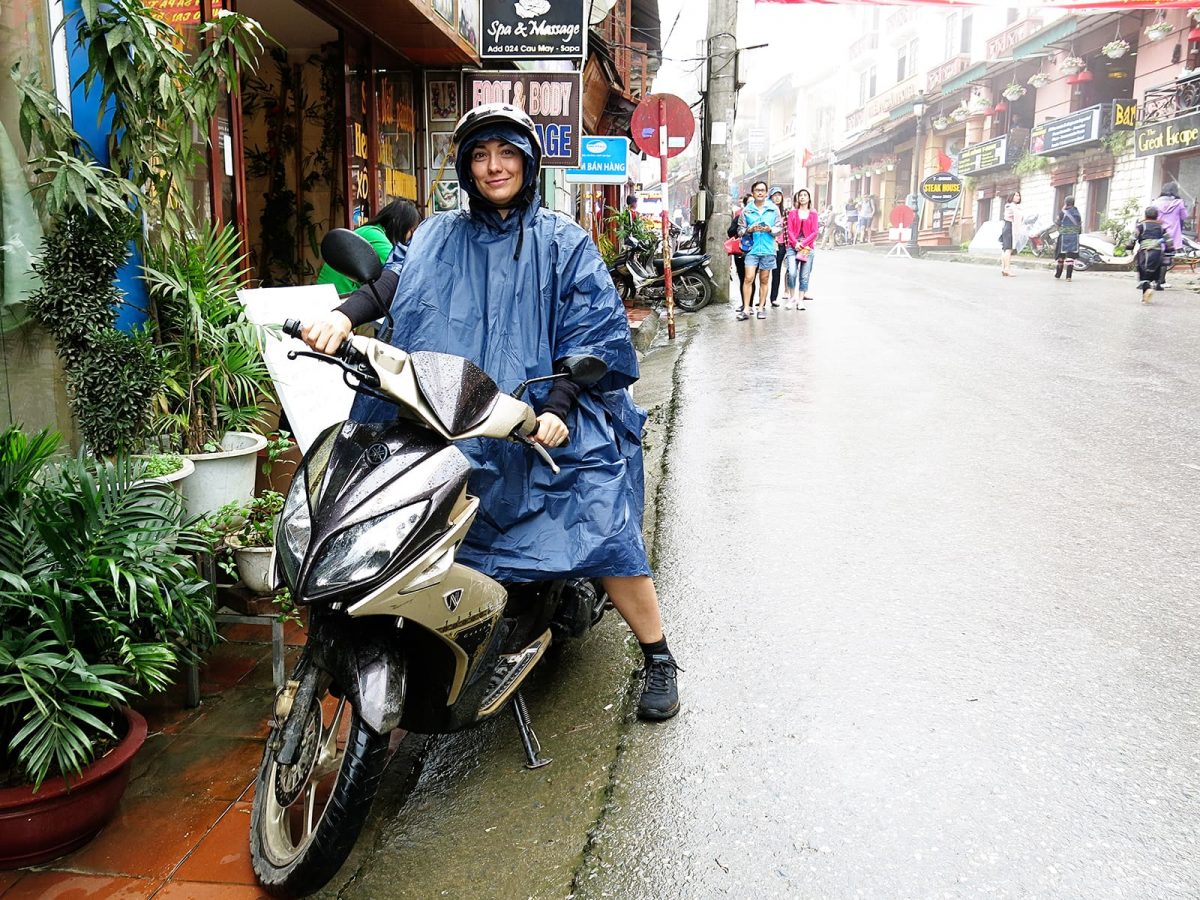 lady in a poncho on a scooter in Vietnam, street in the rain