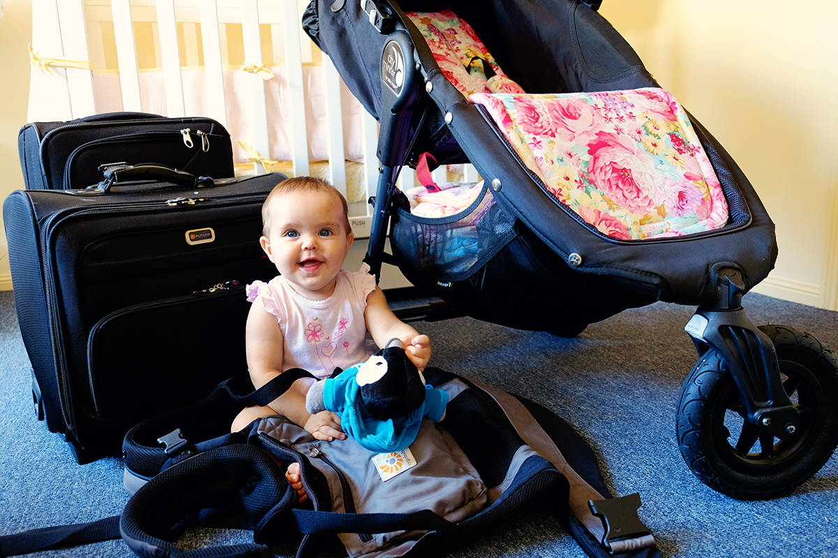 Top 10 Tips for Flying with Baby, Baby playing with a toy, luggage, strollers, baby carrier in the picture