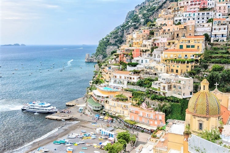 Positano, Amalfi Coast, Italy, view of the colourful buildings on the side of the mountain, beach, boats and ferry