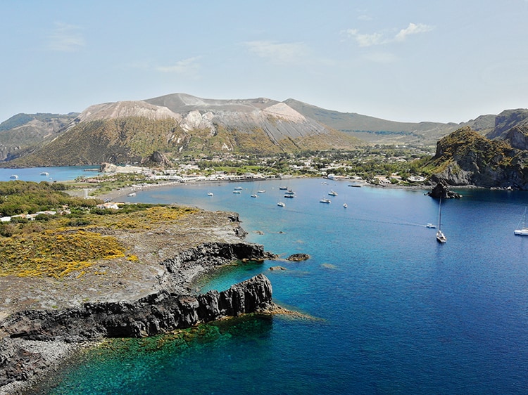Aeolian Islands Sicily, Italy, aerial view of  an island, boats in the water, town in the distance