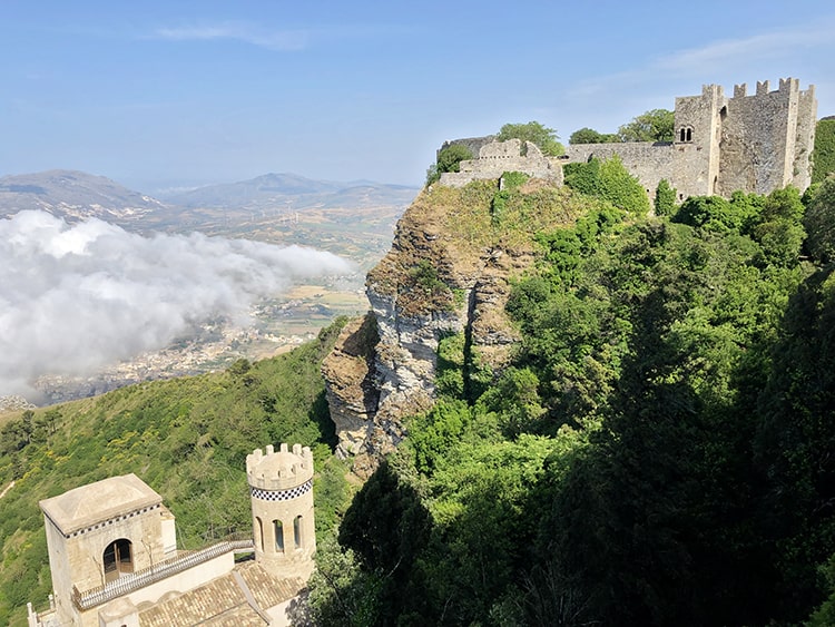 Erice Italy, Old castle ruins at the tops of the mountains, clouds, town and lands below