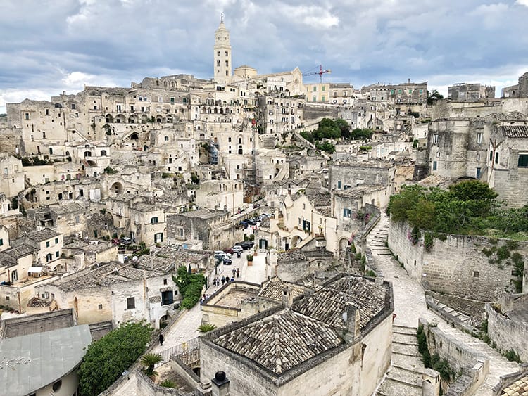 Southern Italy holidays to Matera Sassi, ancient city of Matera, stone buildings grey and cream colour, church tower in the distance