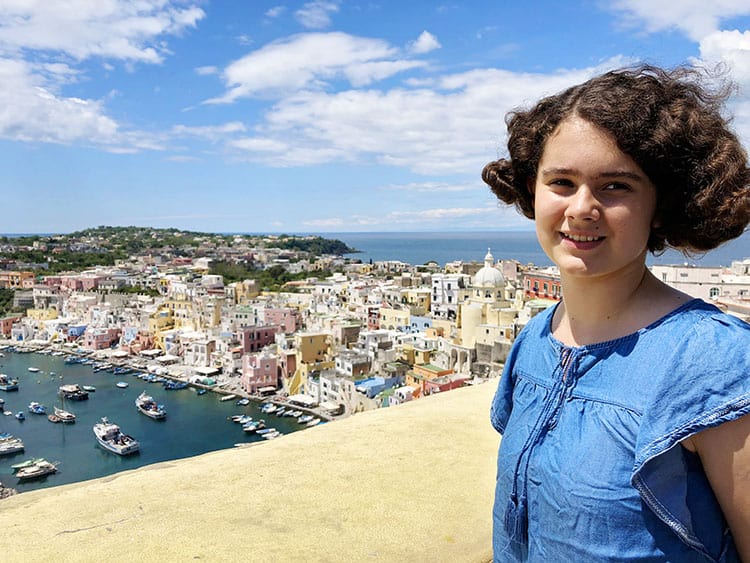 Teenager posing at the Marina Coricelli view point, boats and colourful buildings in the back, girls smiling
