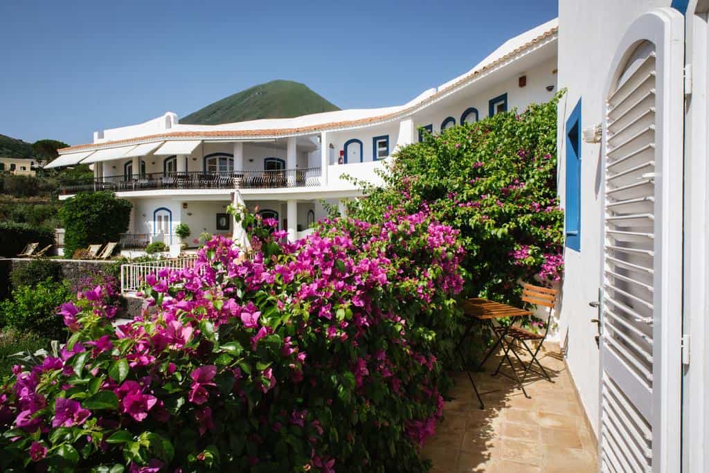 Hotel Punta Scario - top hotels in Salina, white hotel, patios, green bushes  with pink flowers