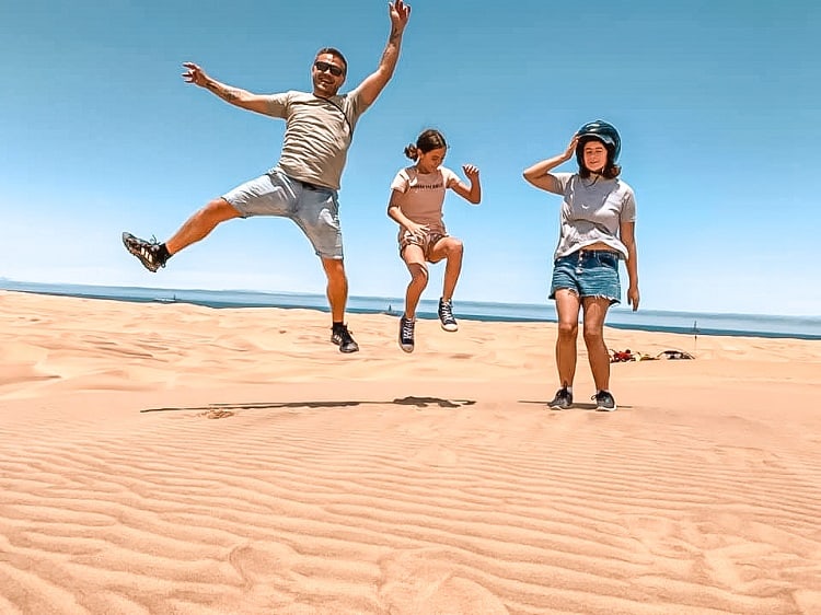 What to do with Kids in Swakopmund - Daredevil Adventure, father and two daughters jumping on the sand Dunes