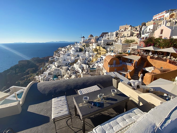 Santorini in September, Greece - Accommodation in Oia, rooftop balcony view from the top, dining table and seats, buildings